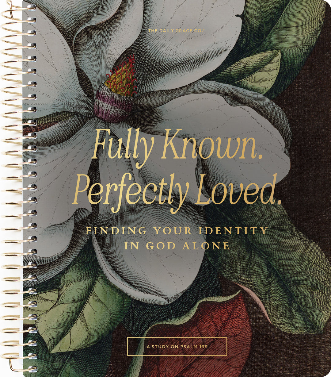 A spiral-bound book cover featuring a large illustrated white magnolia flower with green leaves and gold text reading 'Fully Known. Perfectly Loved.