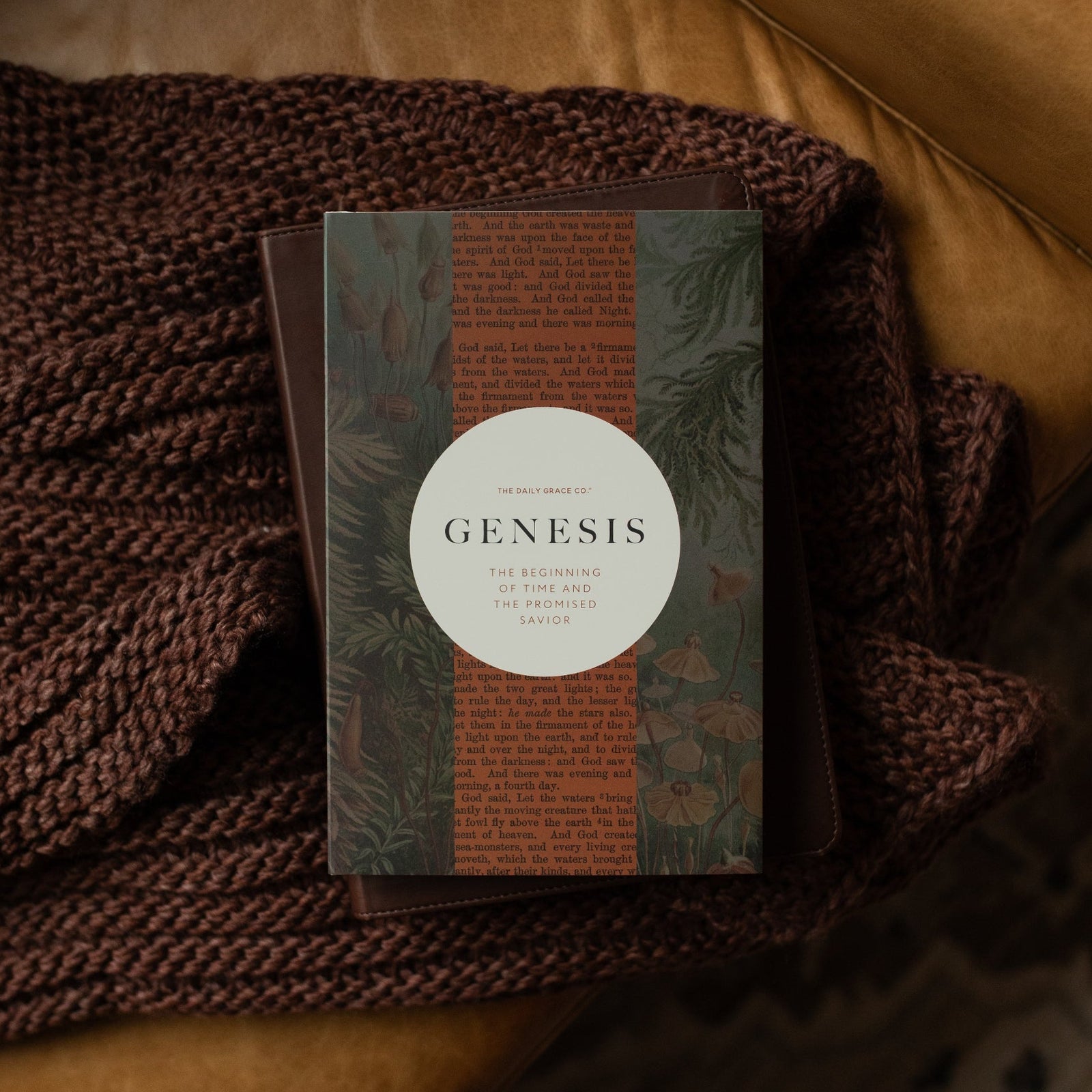 Genesis Hardcover study on a closed bible on a woven blanket on a leather couch