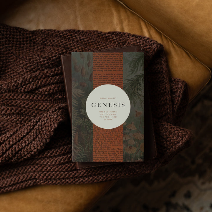 Genesis Hardcover study on a closed bible on a woven blanket on a leather couch