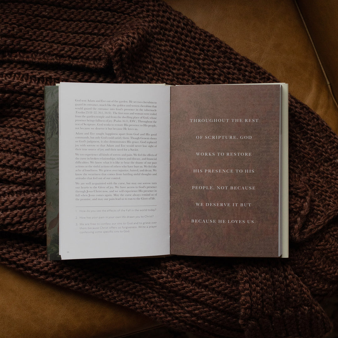 Genesis Hardcover study opened to the small devotional page on a woven blanket on a leather couch