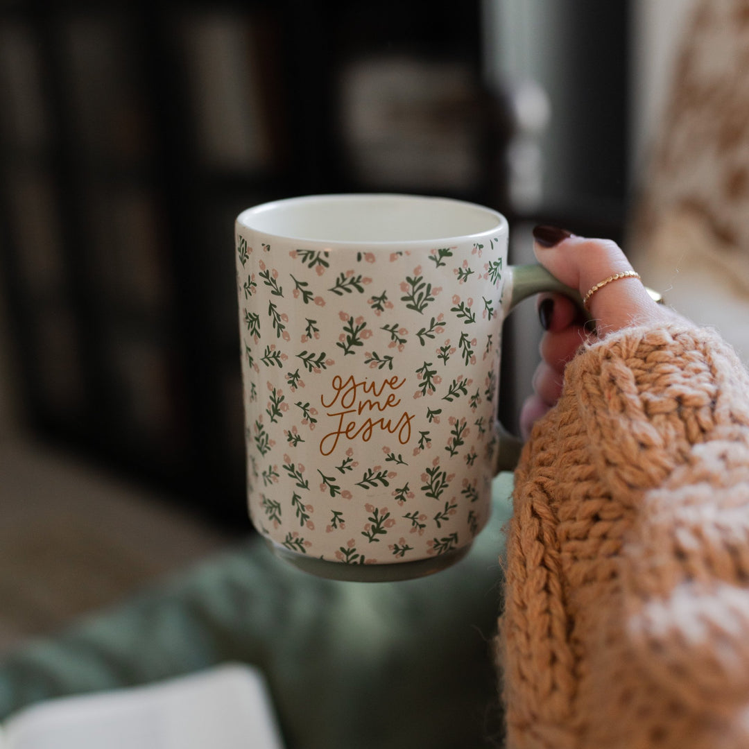 woman holding floral white coffee mug that says Give Me Jesus