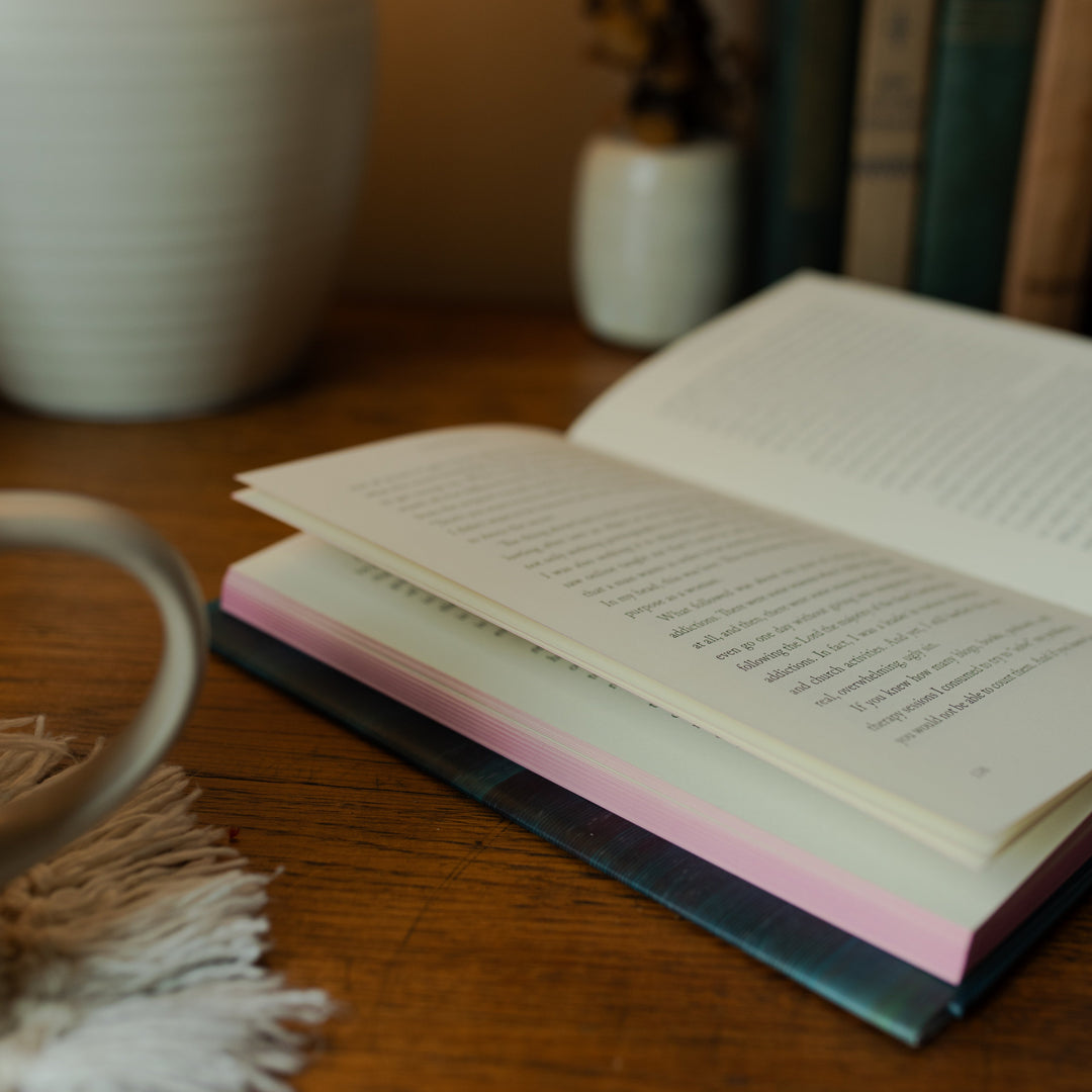 The Good Christian Girl Book opened to a random page on a wooden table near vases