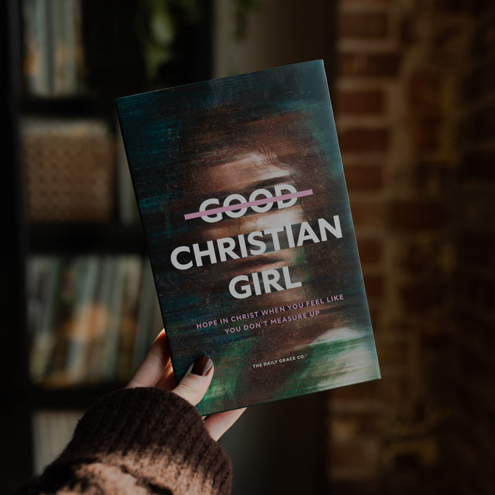 A woman holding up The Good Christian Girl book with one hand