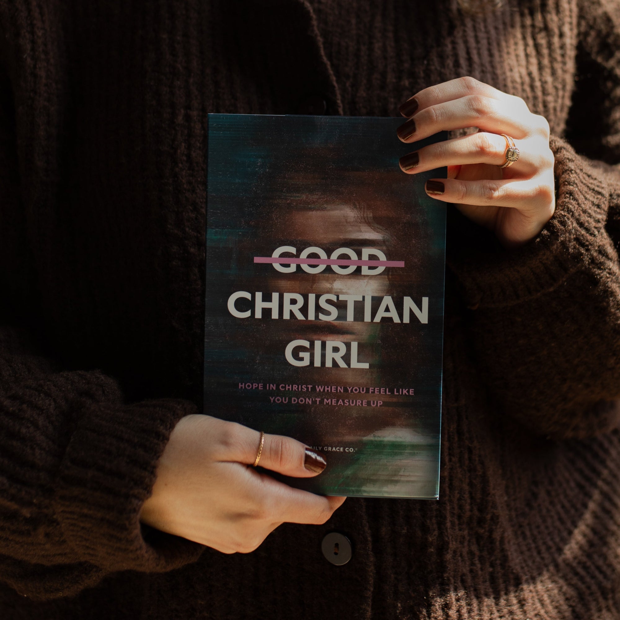 A woman holding up The Good Christian Girl book