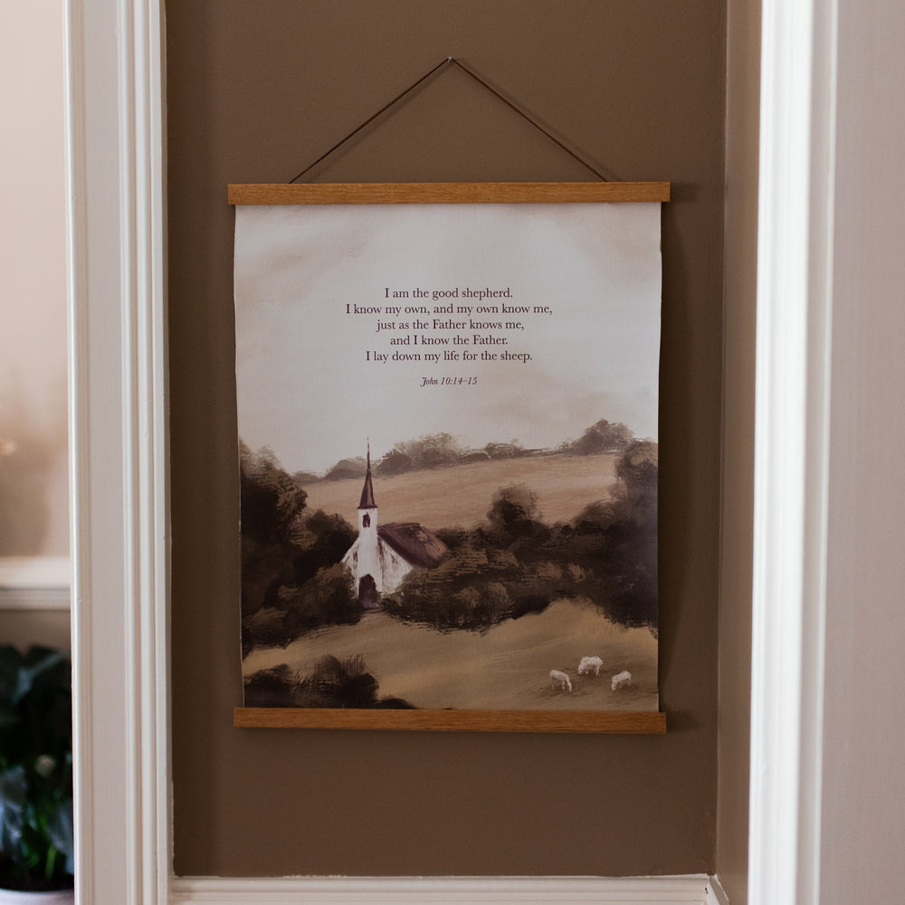 The Good Shepherd Canvas Print hanging on a brown wall with white trim
