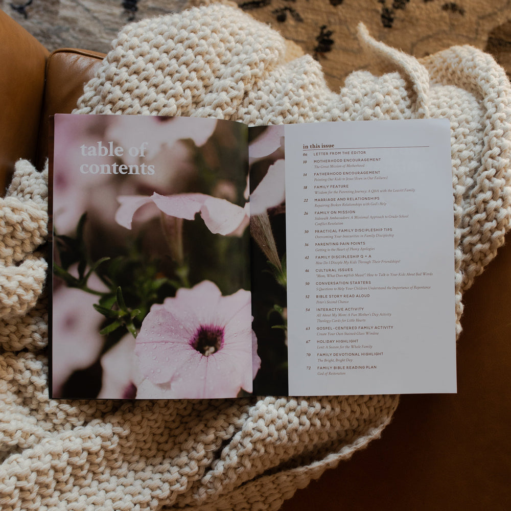 Gospel at Home Issue 11 opened to the table of contents page on a white knitted blanket