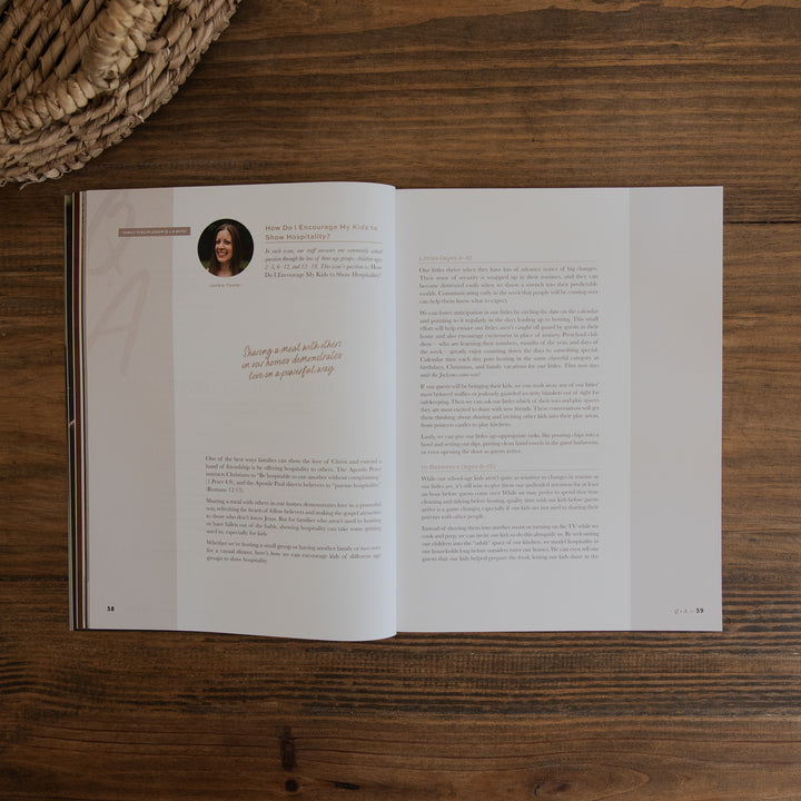 An open printed magazine spread laid flat on a dark wood surface, with a woven basket edge visible in the top-left corner.