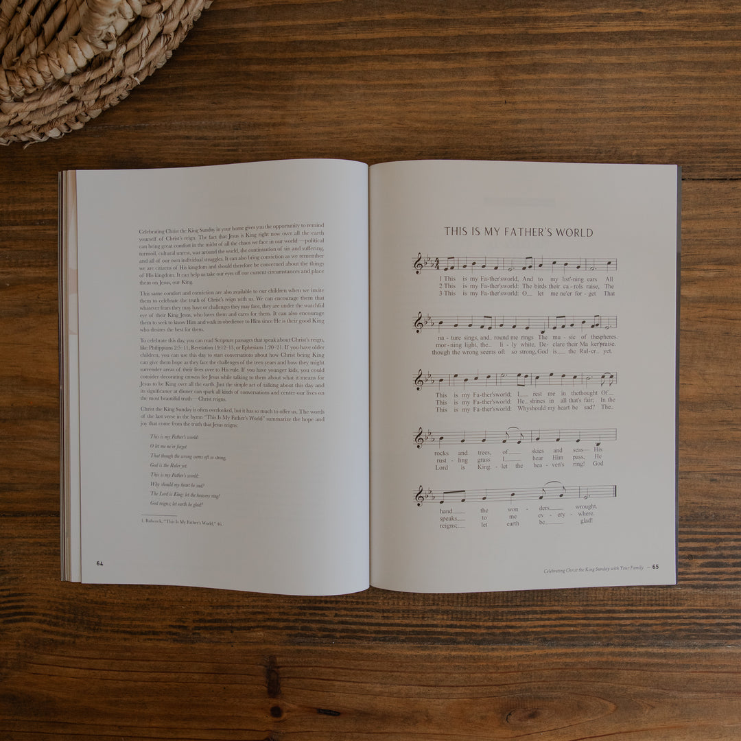 An open magazine laid flat on a wooden table, showing printed text on the left page and sheet music titled 'THIS IS MY FATHER'S WORLD' on the right page. A woven basket edge is visible in the top-left corner.