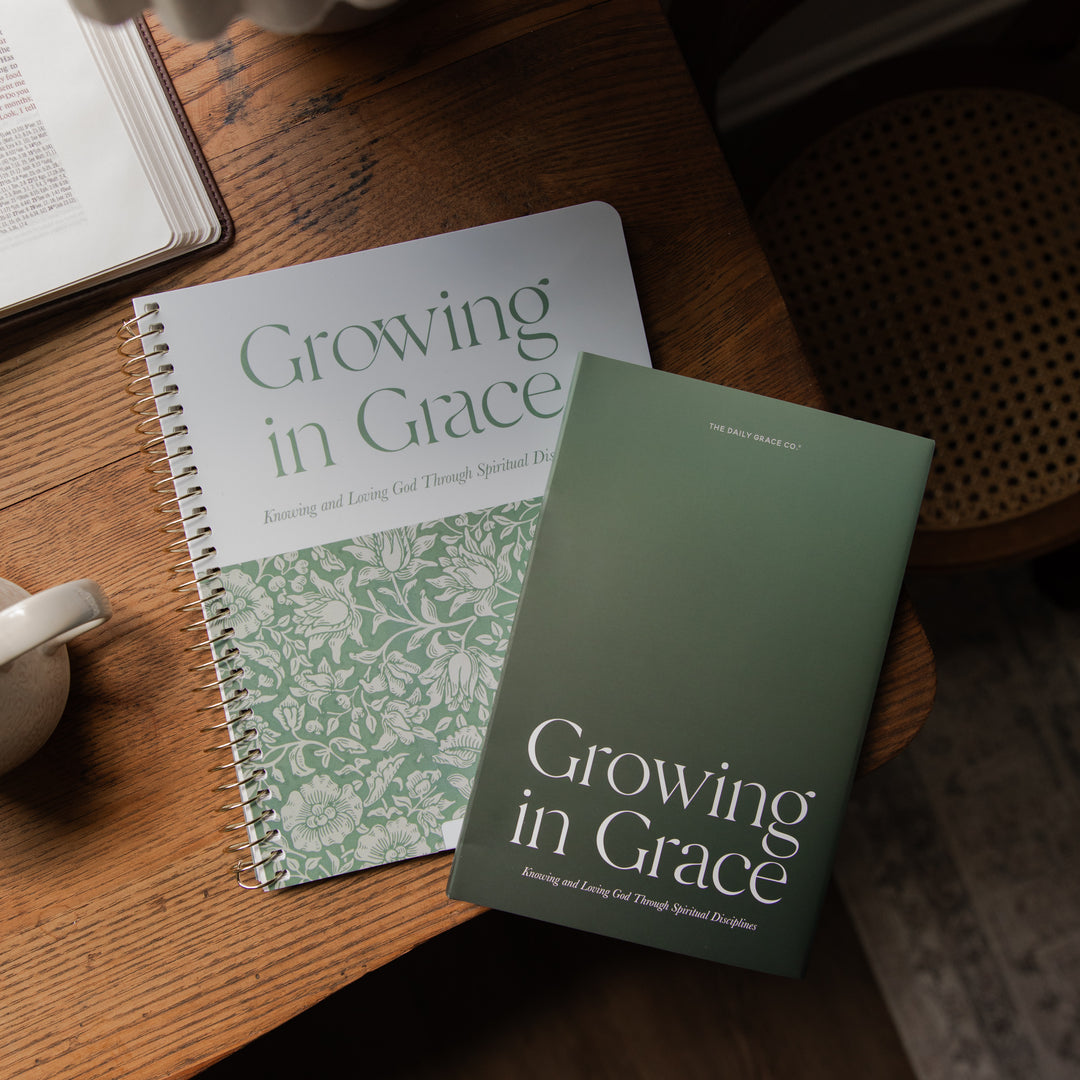 Two copies of the book 'Growing in Grace: Enjoying and Loving God Through Spiritual Discipline' are shown on a wooden table, one open and one closed.