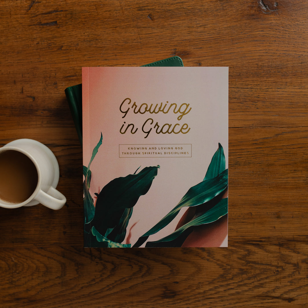 Book titled 'Growing in Grace' on a wooden surface with a cup of coffee.