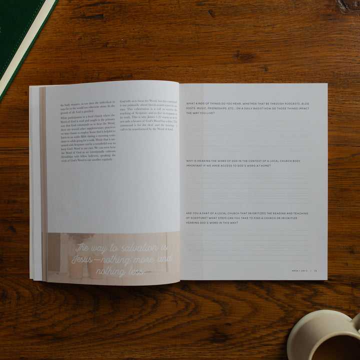 Open book on a wooden surface with a cup of coffee.