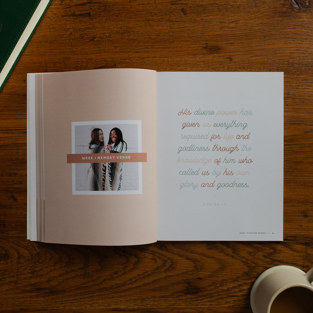 Open book on a wooden surface with text and a photo of two people.