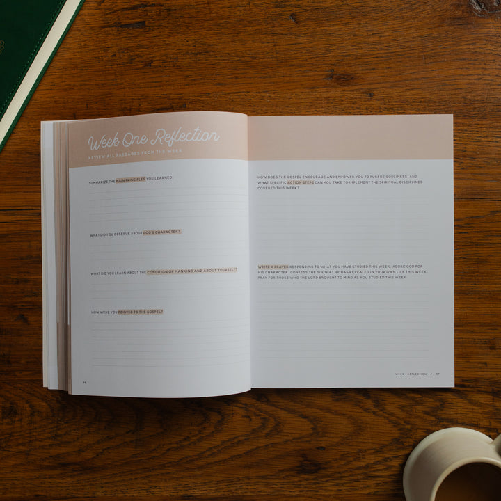 Open book on a wooden surface with a cup of coffee.