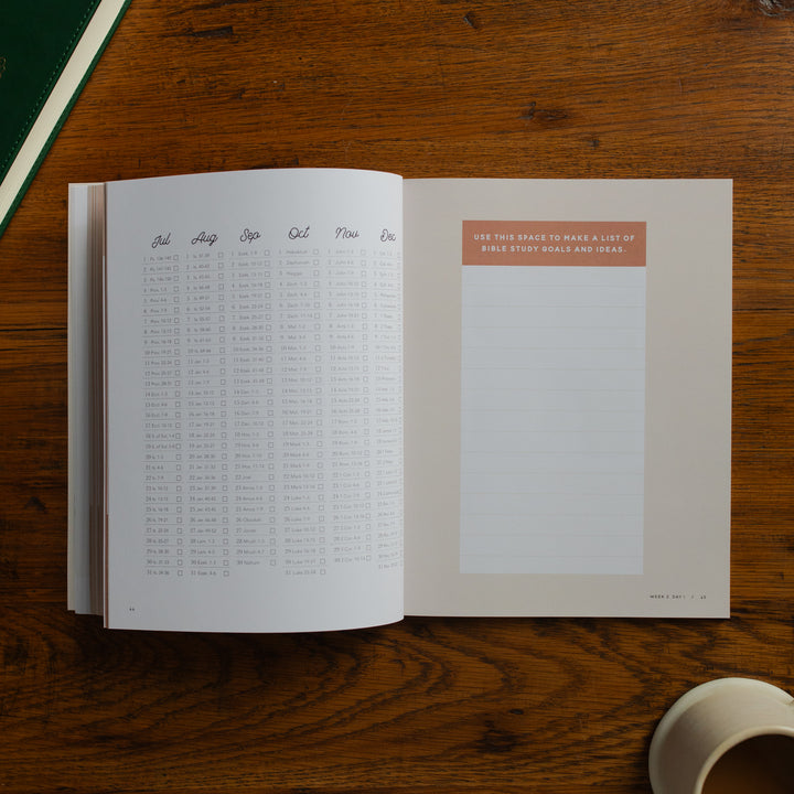 Open book on a wooden surface with a cup of coffee.