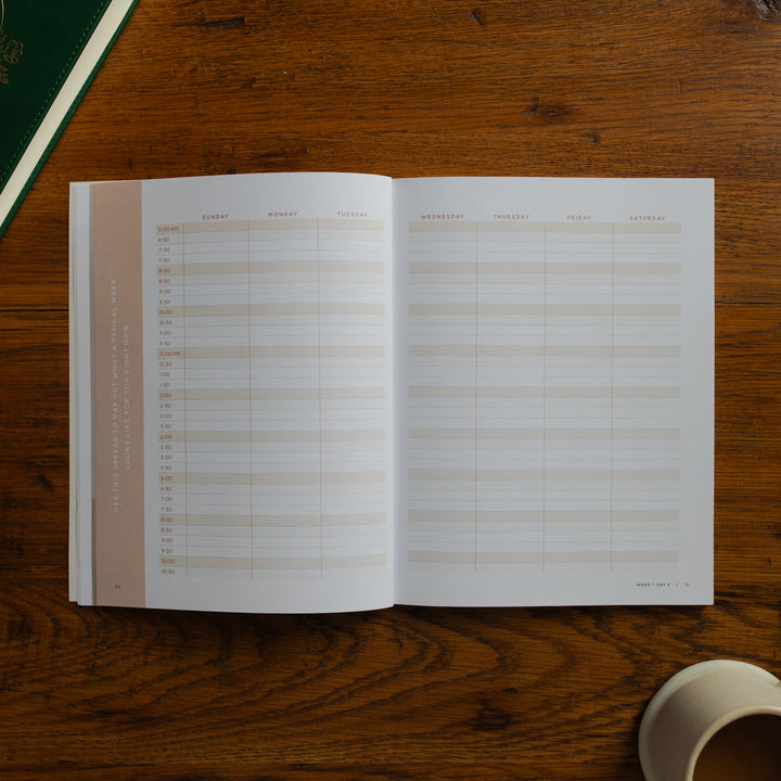 Open planner on a wooden surface with a cup of coffee