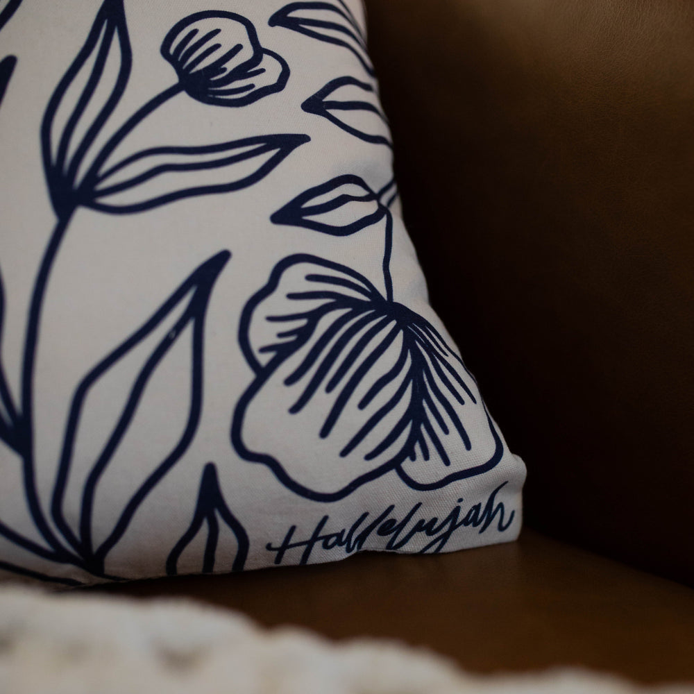 Close up of word hallelujah in bottom corner of floral pillow cover