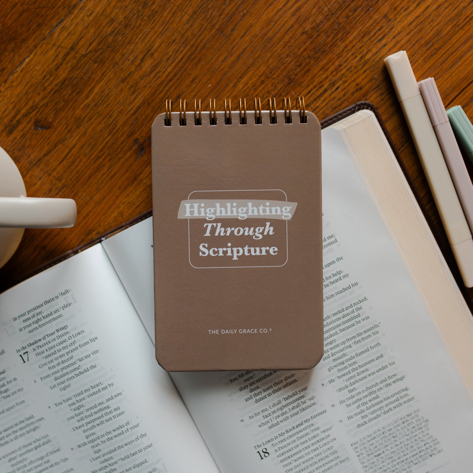 Highlighting through Scripture flipbook on an open bible on a wooden table near some highlighters