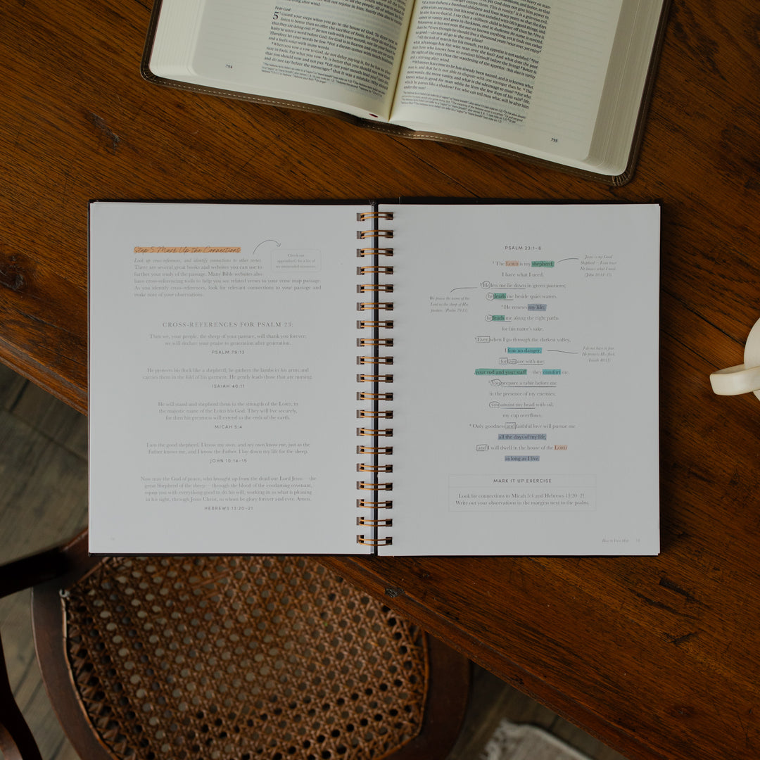 Identity in Christ Verse Map Journal opened to the mark up the connections page on a wooden table near a coffee mug and an open bible
