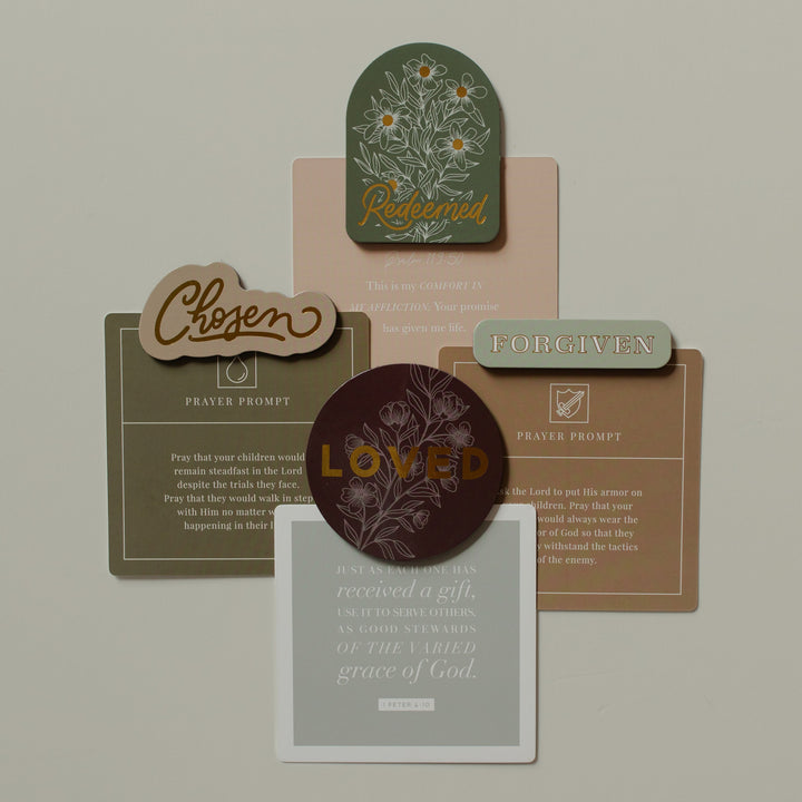 All of the Identity Magnets holding verse cards on a white surface