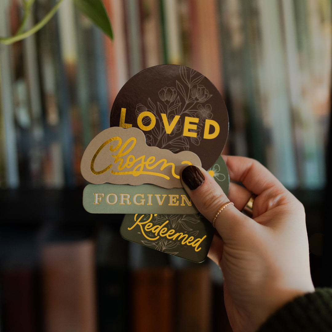 A woman holding all of the Identity Magnets holding verse cards in her hand