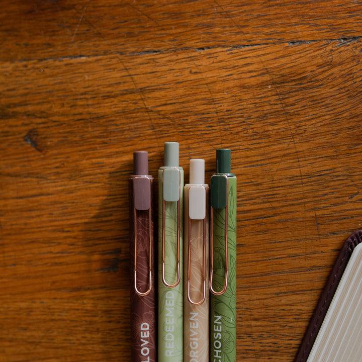 Up close of all four of the Identity Pen Set on a wooden table