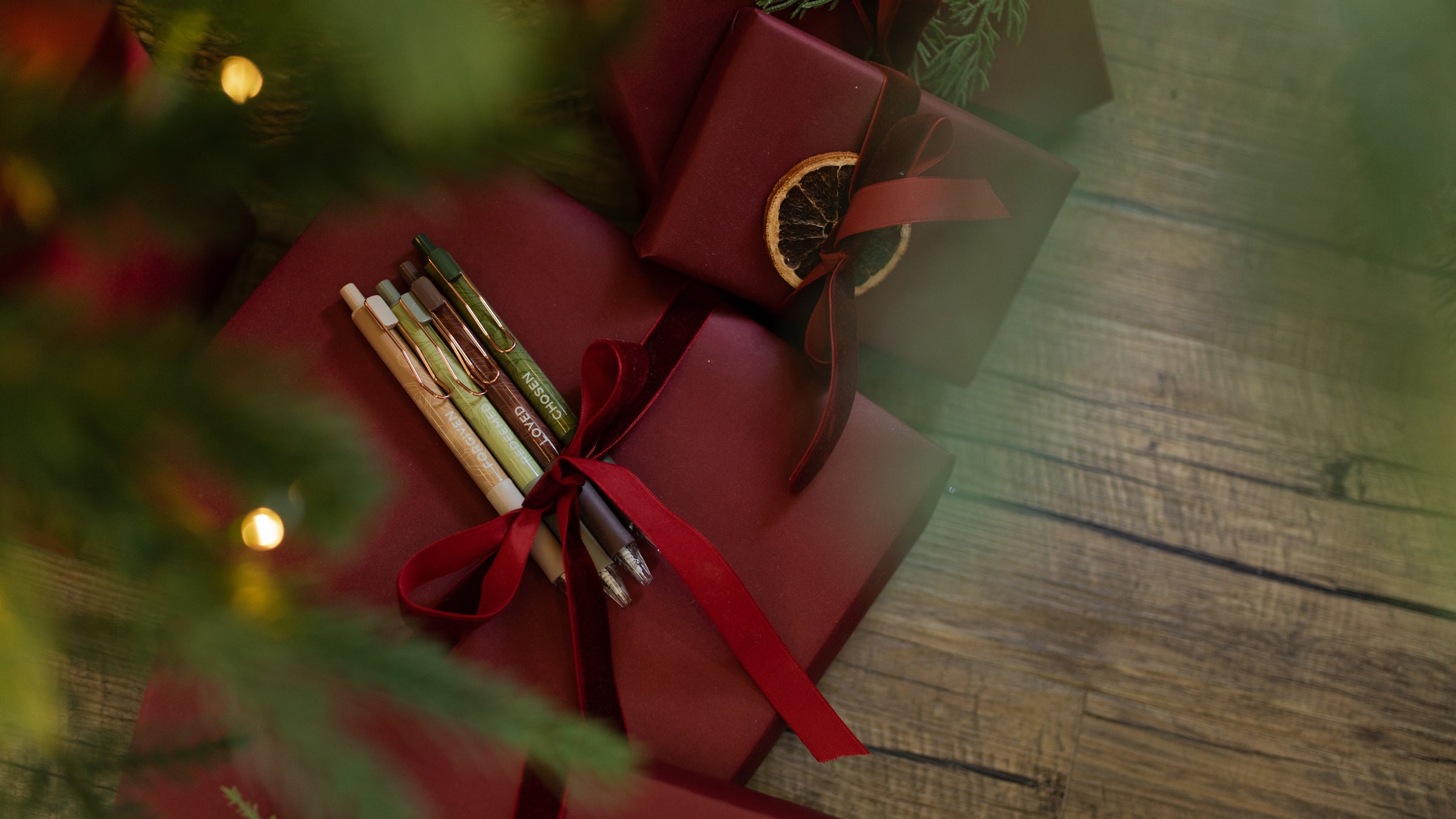 The Identity Pen Set wrapped in a red ribbon on a red wrapped gift