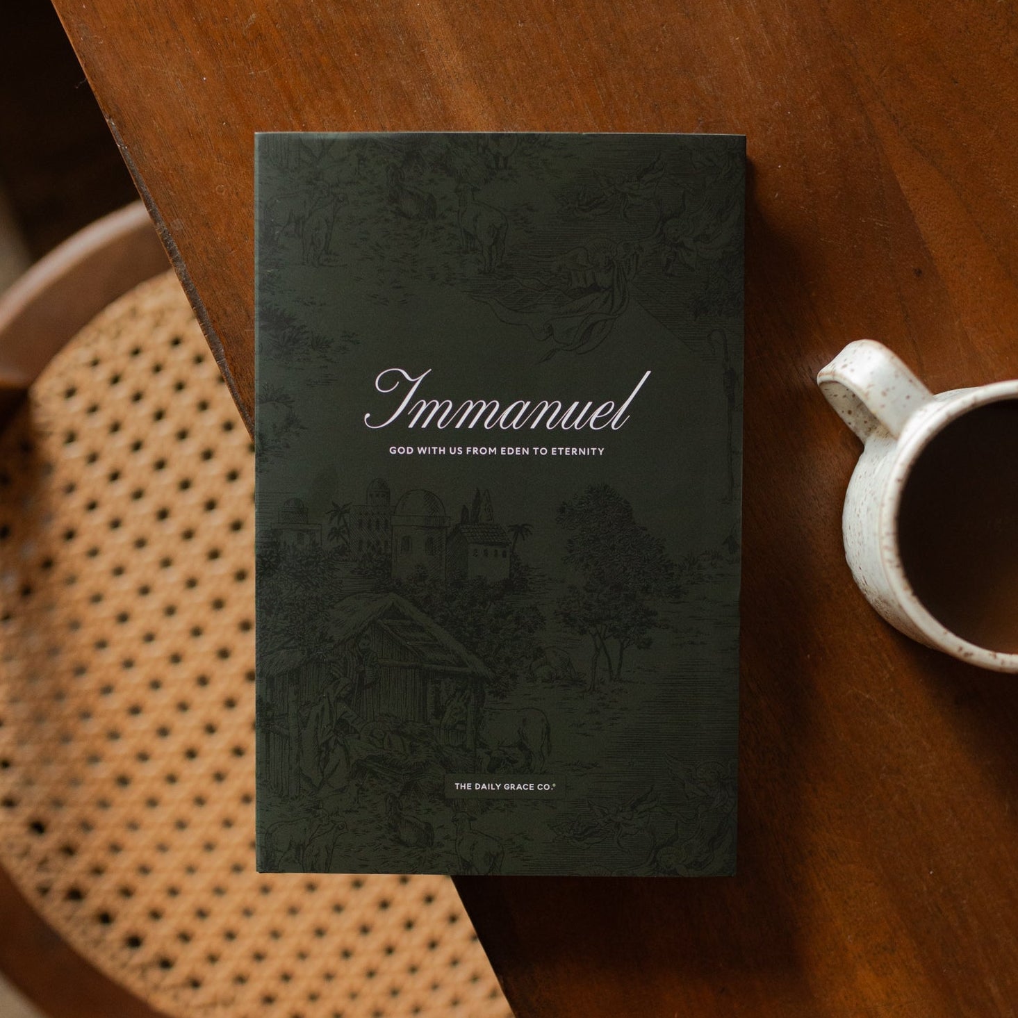 The Immanuel Hardcover cover on a wooden table next to a coffee cup