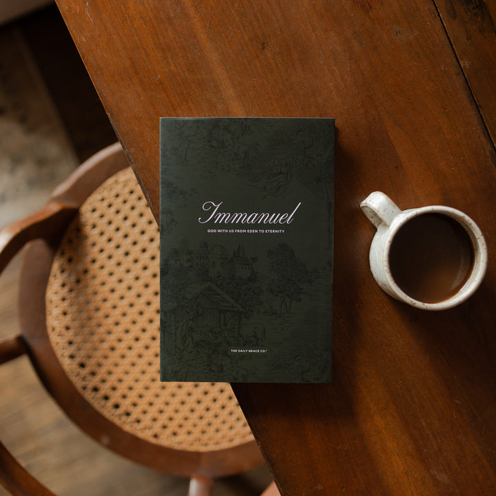The Immanuel Hardcover cover on a wooden table next to a coffee cup