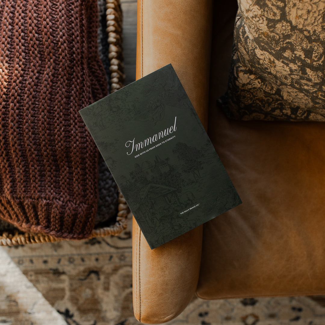 The Immanuel Hardcover cover on a leather arm rest near some blankets and a pillow