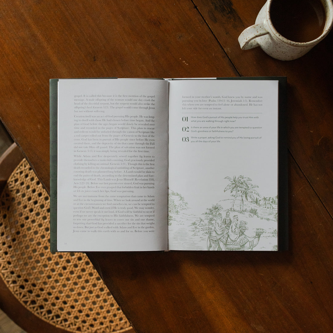 The Immanuel Hardcover opened to the applications page on a wooden table next to a coffee cup