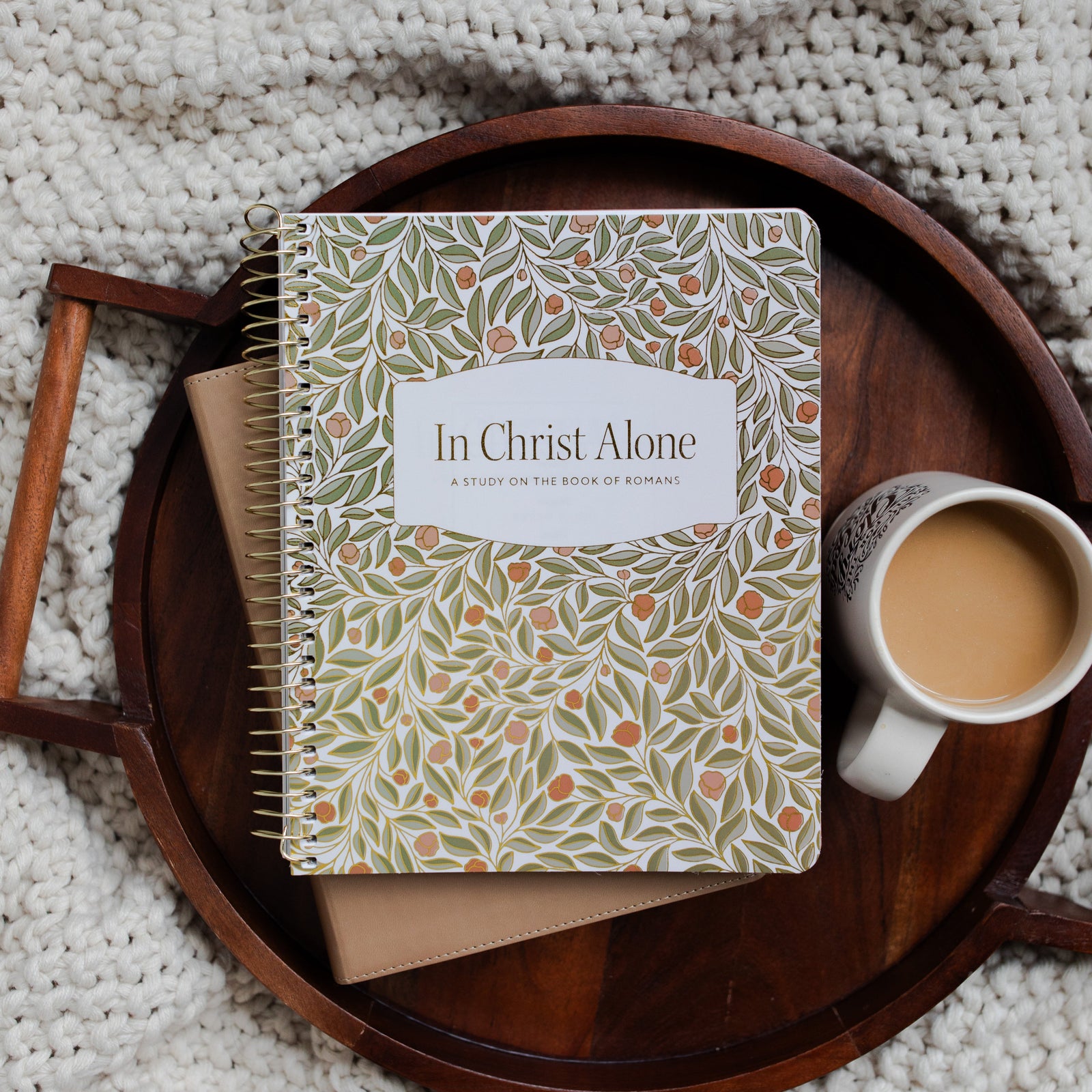 In Christ Alone Study Cover on a Bible next to a white coffee cup on a wooden tray on a knitted blanket