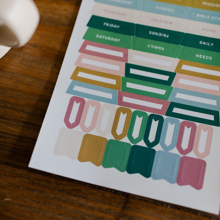 In Everything Journal Sticker Sheet up close of bottom corner on a brown wooden table