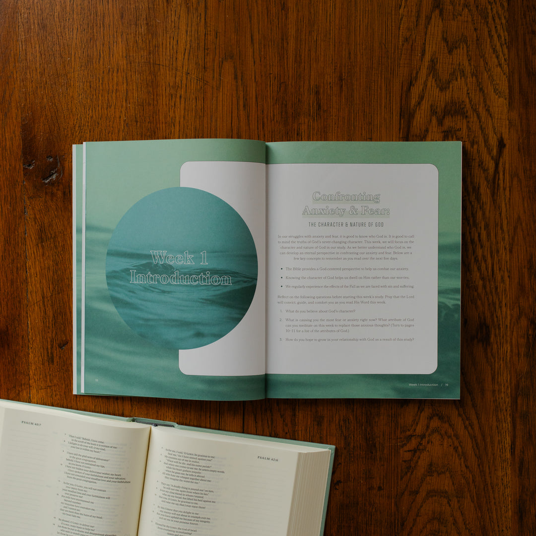 It is Well Teen Study opened to the week 1 introduction page on a wooden table next to an open bible