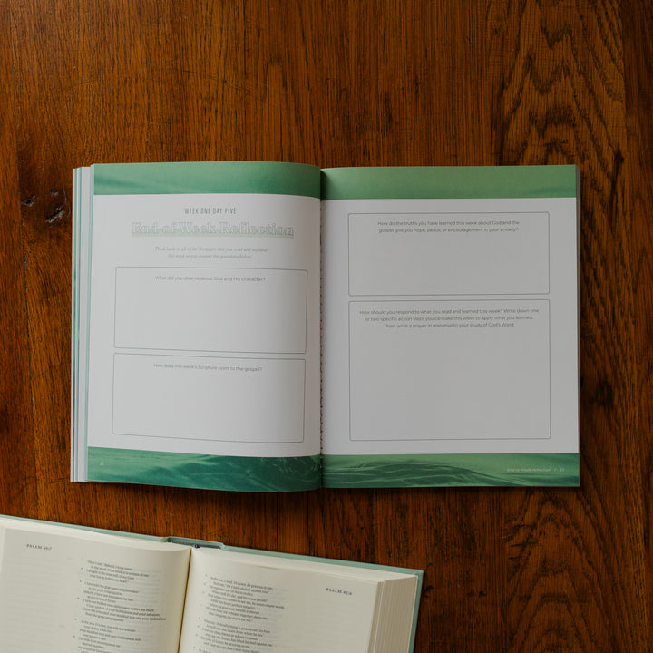 It is Well Teen Study opened to the end of the week reflection page on a wooden table next to an open bible