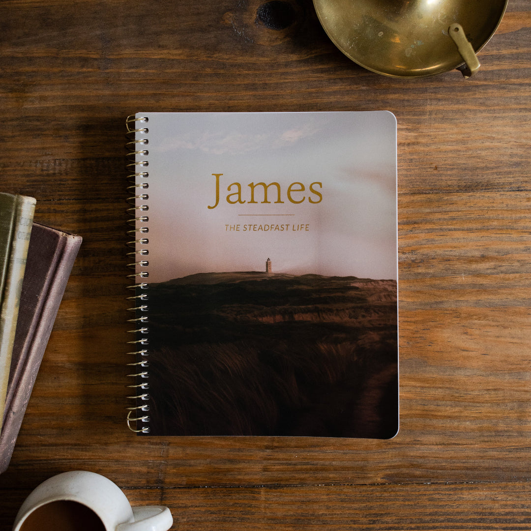 James Men's Spiral study Cover on a wooden table next to a bronze oil lamp