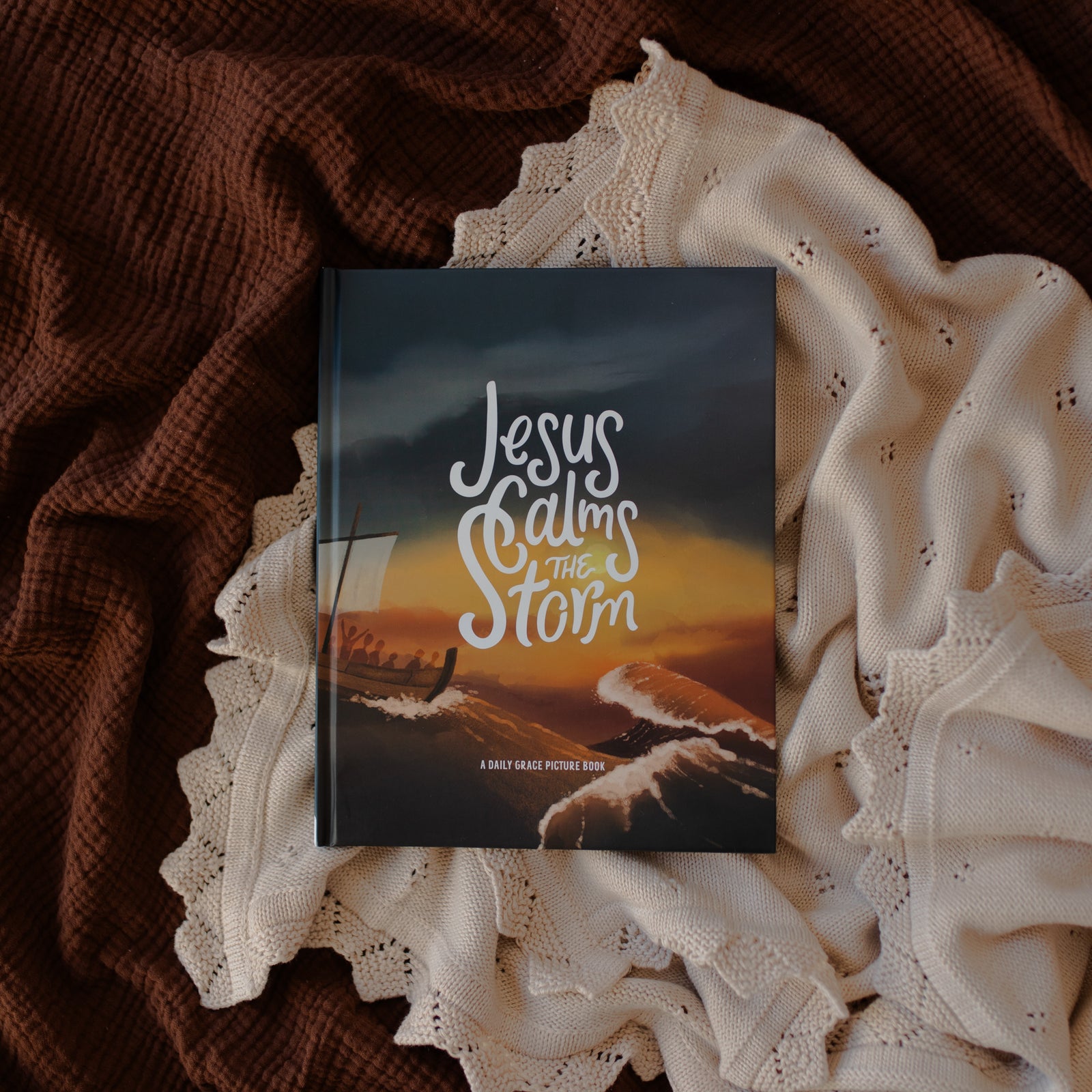 Jesus Calms the Storm Picture Book Cover on a white and brown blanket