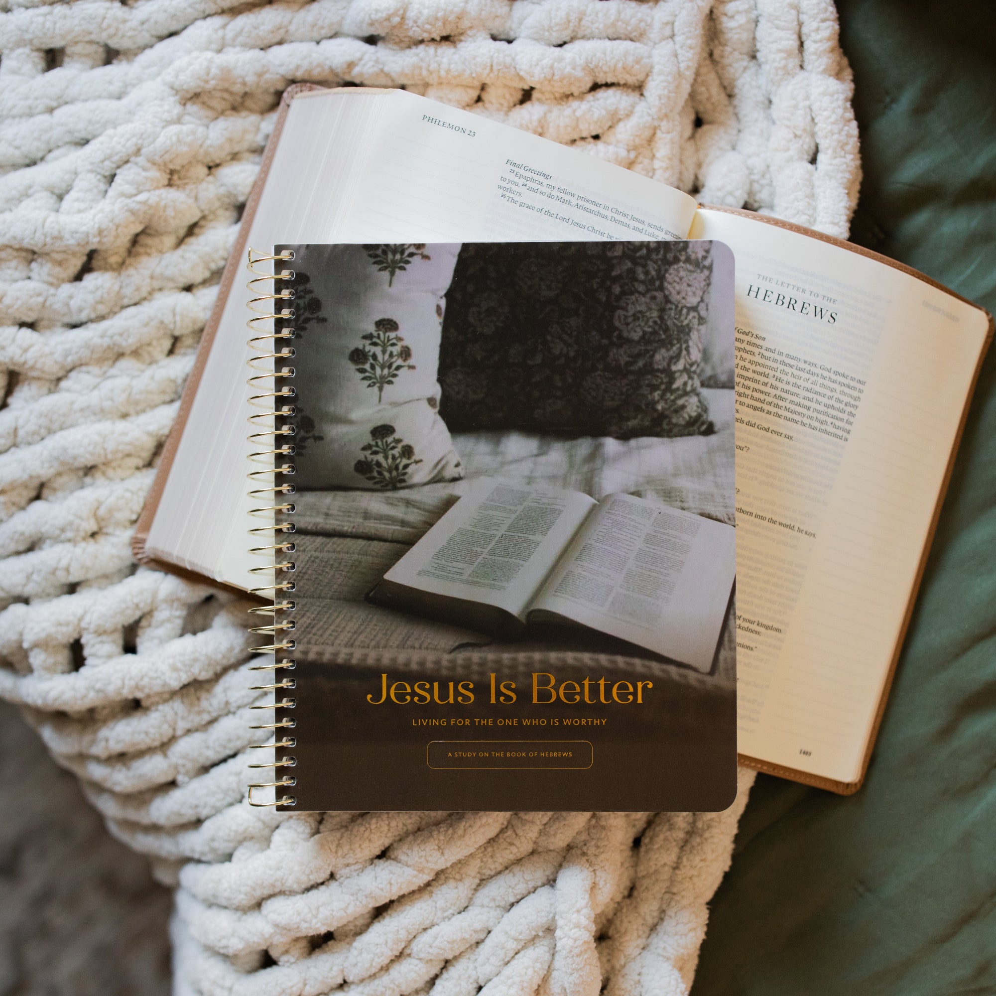 Jesus is Better study cover laying on an open bible on a white knitted blanket