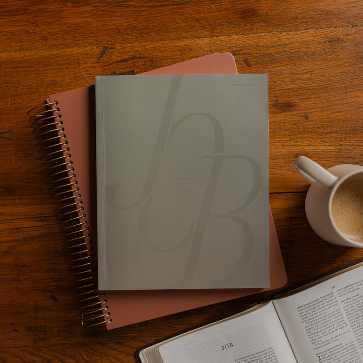 Job Softcover cover on a spiral journal on a wooden table near a coffee cup