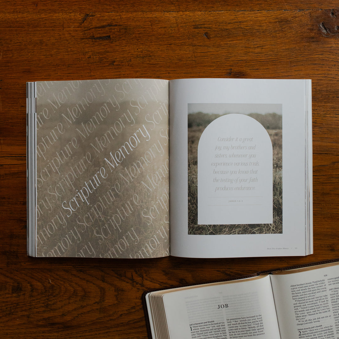 Job Softcover opened to the scripture memory page on a wooden table