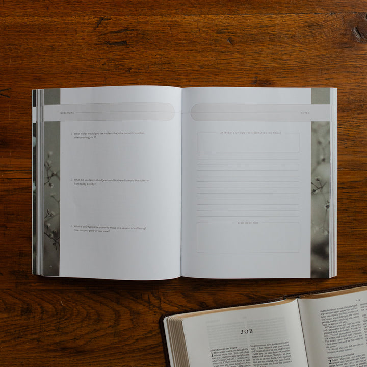 Job Softcover opened to the questions and applications page on a wooden table