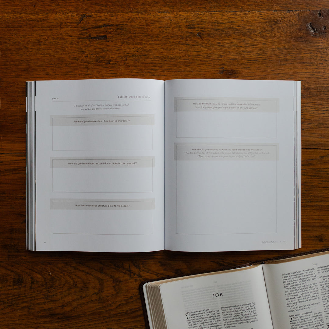 Job Softcover opened to another applications and questions page on a wooden table