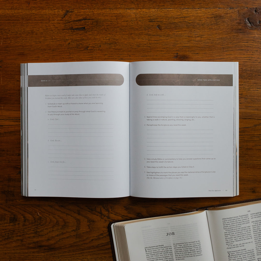 Job Softcover opened to week 2 applications and questions page on a wooden table