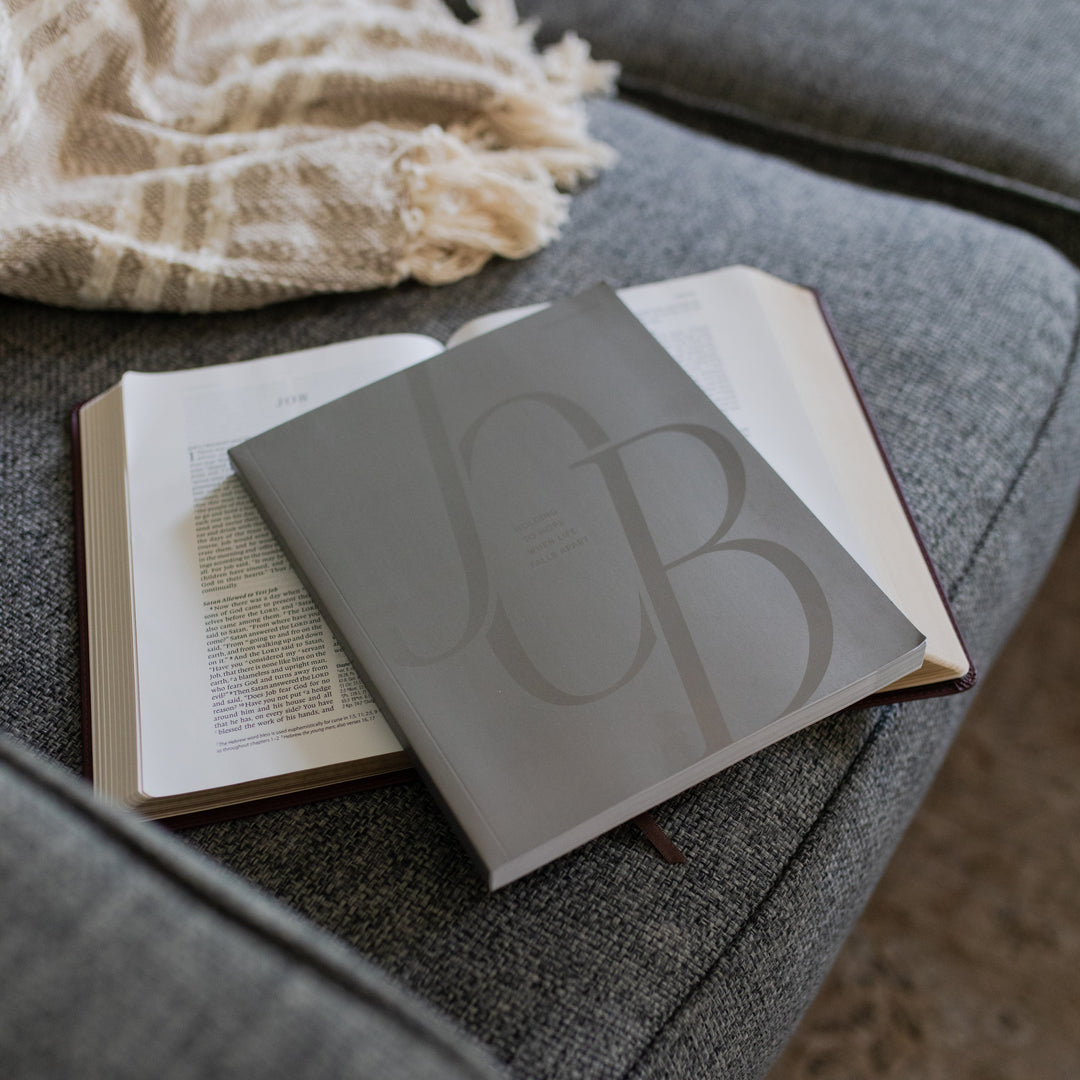 Job Study cover resting on an open bible on a grey couch