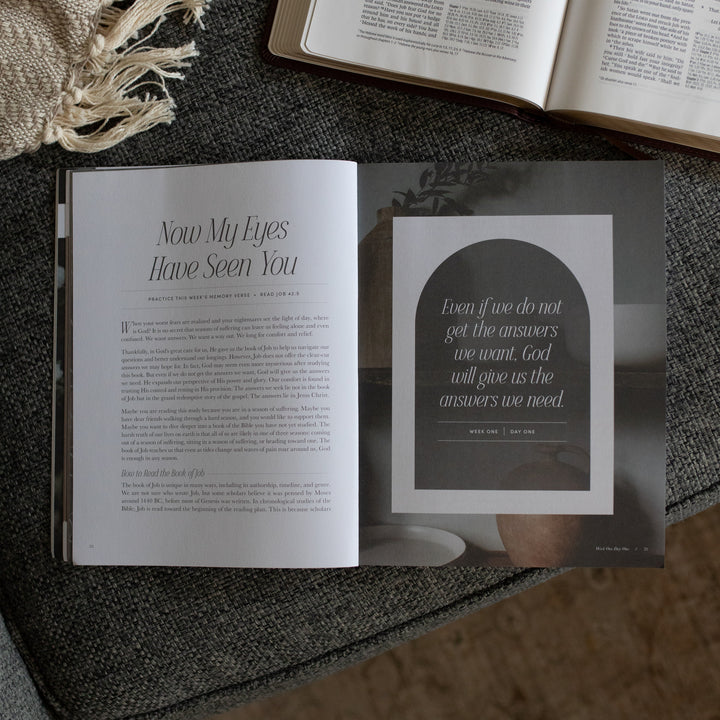 The Job study opened to the Now my Eyes Have Seen You page near an open bible on a grey couch