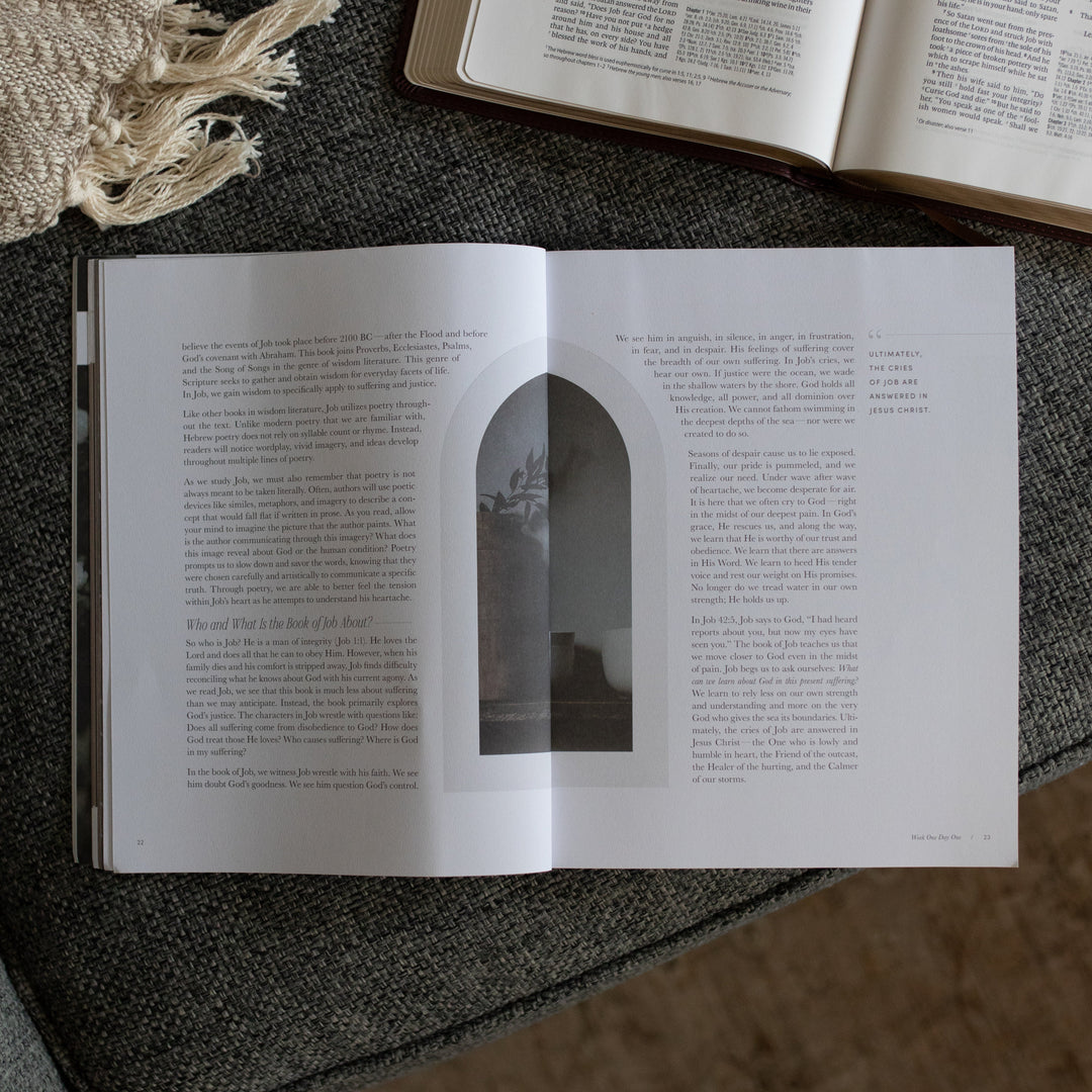 The Job study opened to the week 1 day 1 page near an open bible on a grey couch