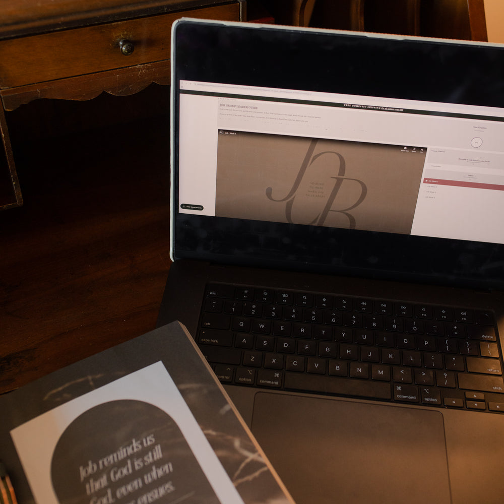 Up close of the Job Group Leader Guide on a laptop near an open study on a wooden table