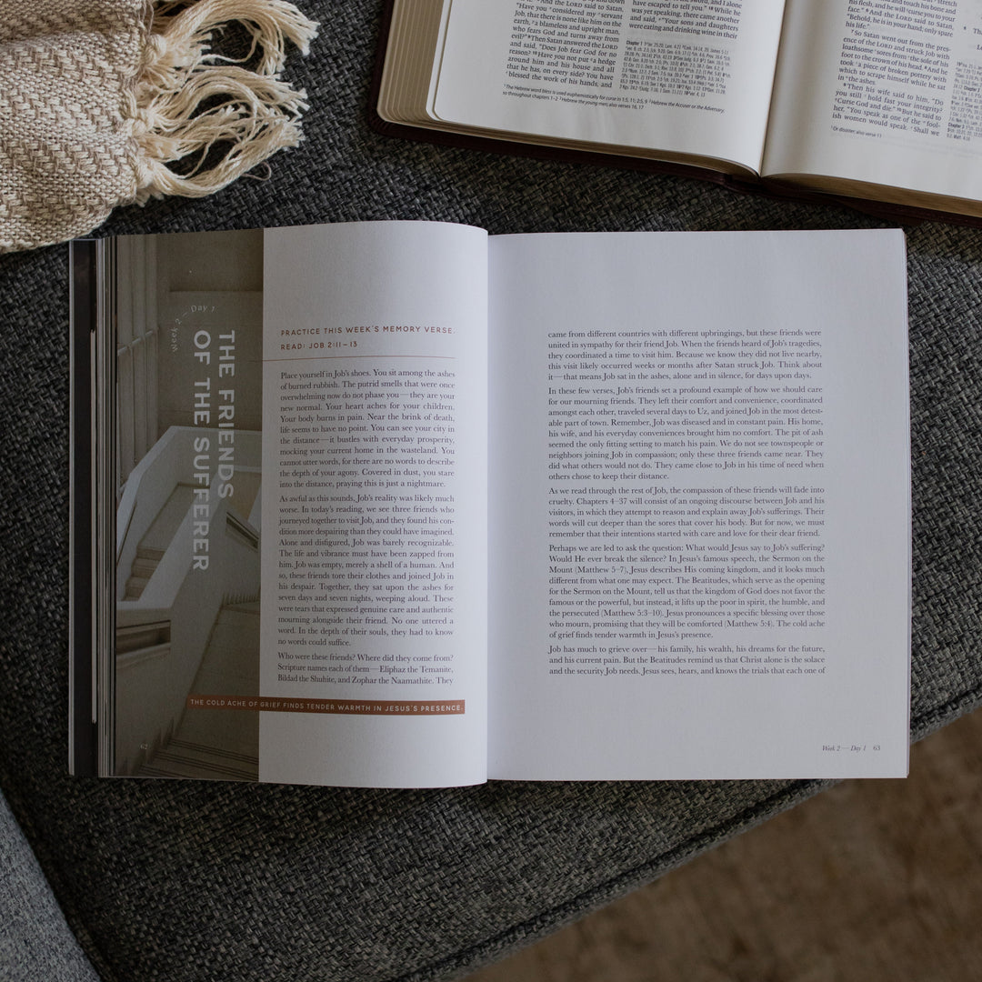 The Job Study Men's version opened to the Friends of the sufferer page next to an open bible on a gray couch