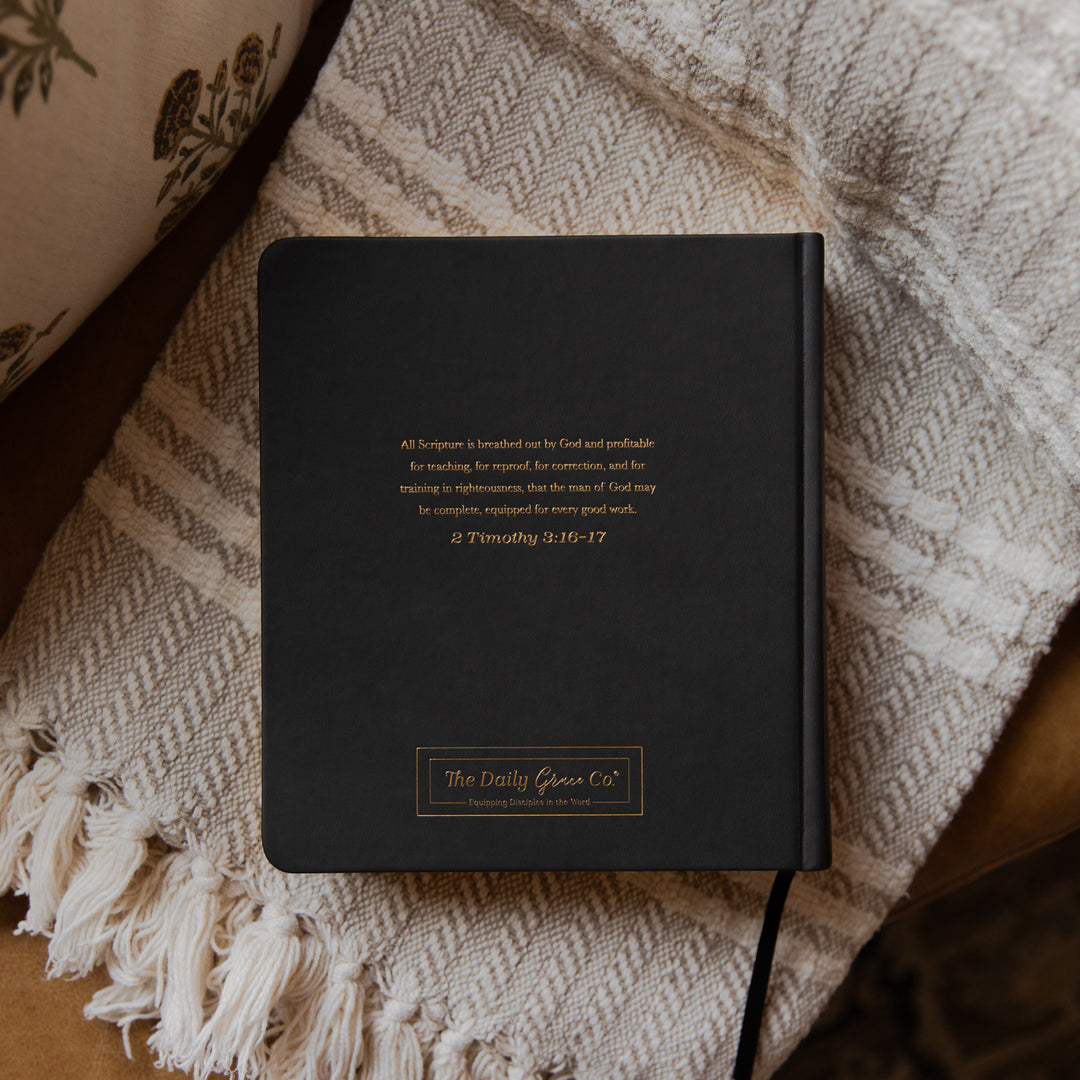 Black bible with text on a textured fabric surface