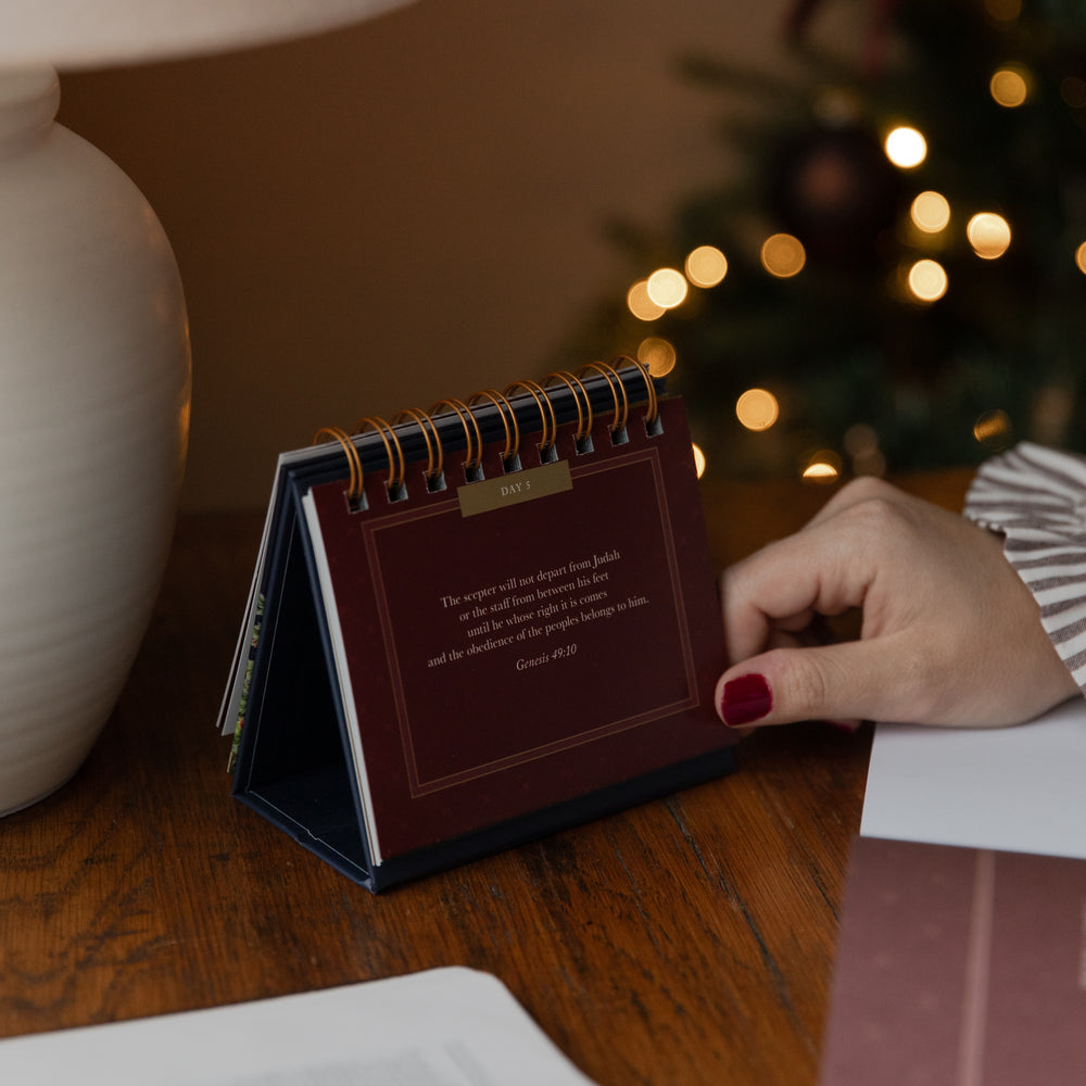 A womans hand on a flipbook resting on a table