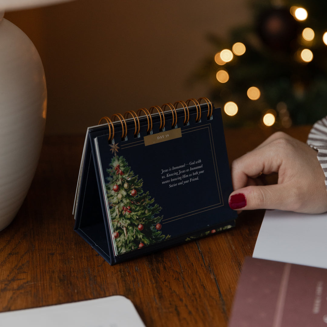 A womans hand on a flipbook resting on a table on day 19